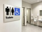 Braille and tactile toilet sign wall mounted at an amenities entrance