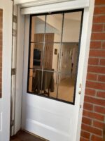 TradeBase 316 marine grade stainless steel flyscreen mesh in a timber screen door viewed from inside, clear view through to courtyard