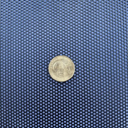 Black perforated aluminium security mesh with an Australian dollar coin on it for scale, showing 2mm round holes on 5mm staggered pitch